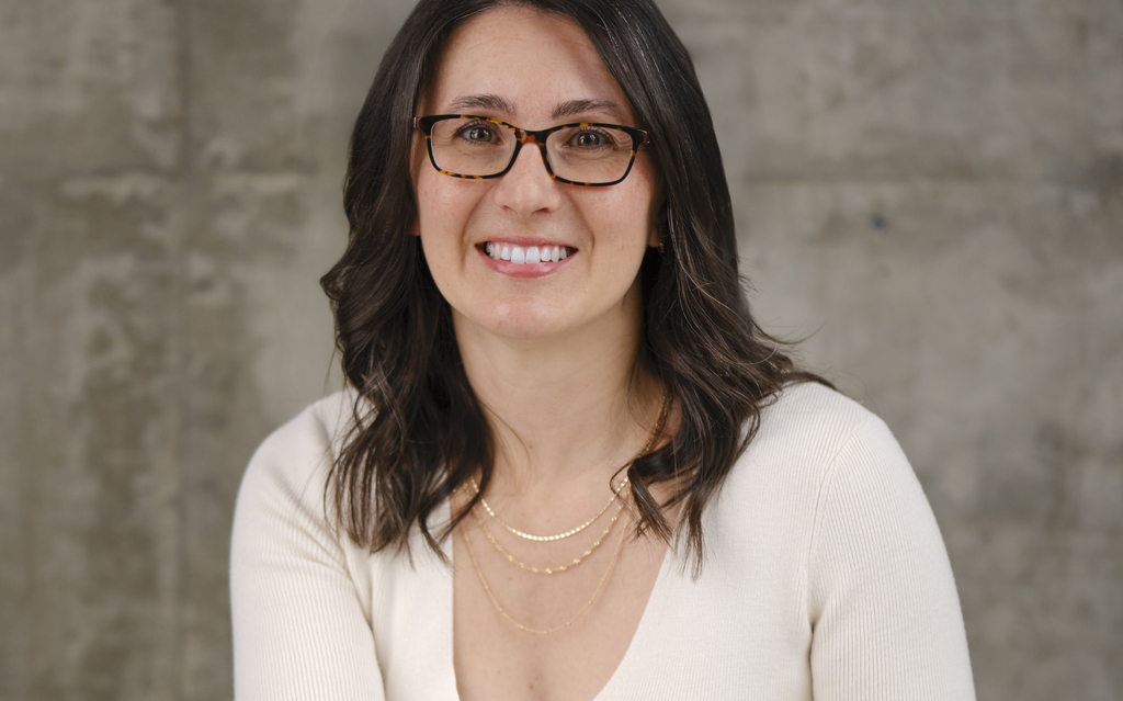 Picture of author Erin Forget in a white shirt on a grey background. 